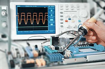 A technician working on an electronic board using digital oscilloscope