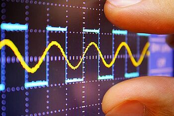 A technician inspecting a signal on a digital oscilloscope