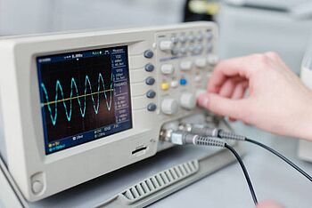 A technician testing a digital oscilloscope